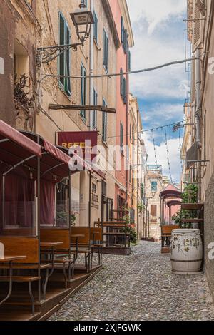 ALGHERO, ITALIE - 3 JUILLET 2024 : rue pittoresque médiévale typique sarde avec petits restaurants traditionnels. Banque D'Images