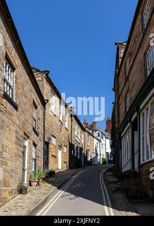 rue étroite et escarpée typique dans robin hoods bay north yorkshire journée d'été ensoleillée pas de gens Banque D'Images