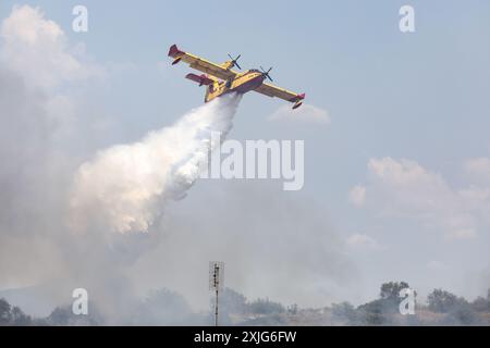 Thessalonique, Grèce. 18 juillet 2024. Un CL-415 Canadair jette de l'eau sur la scène d'un incendie dans la banlieue de Trilofos près de la ville de Thessalonique. (Crédit image : © Giannis Papanikos/ZUMA Press Wire) USAGE ÉDITORIAL SEULEMENT! Non destiné à UN USAGE commercial ! Banque D'Images