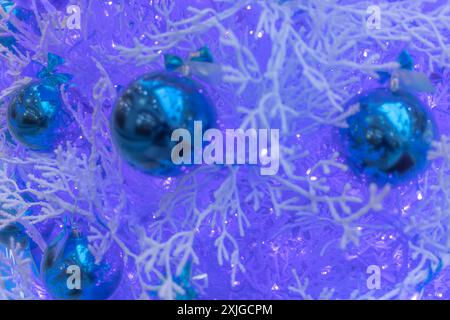 Boules et branches d'arbre de Noël pailletées cyan recouvertes de givre violette. Flou, flou, flou. Gros plan. Copier l'espace, placer pour le texte. Contexte, b Banque D'Images