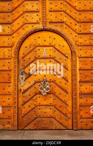 Frappeur de porte orné sur porte en bois avec des montants métalliques dans la vieille ville de Prague en Tchéquie en Europe Banque D'Images
