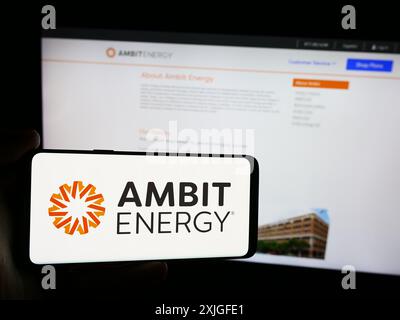 Personne tenant le téléphone portable avec le logo de la société américaine de marketing multi-niveau Ambit Energy devant la page Web de l'entreprise. Concentrez-vous sur l'affichage du téléphone. Banque D'Images