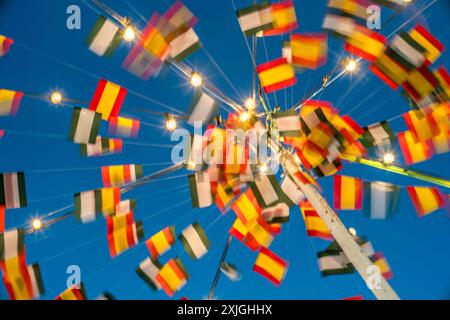 Drapeaux colorés et lumières pendant la foire traditionnelle à Fuenteheridos, Huelva, Andalousie, Espagne mettant en valeur l'esprit festif et la culture locale. Banque D'Images