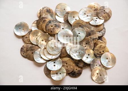 Pile de nacre (nacre) boutons de couture gros plan sur fond blanc Banque D'Images