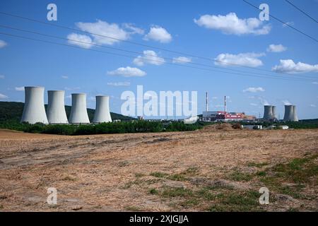 Les grandes tours de refroidissement des centrales nucléaires sont hautes au loin par une journée ensoleillée. Banque D'Images