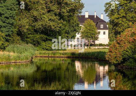 Cottbus, Allemagne. 18 juillet 2024. Le soleil du soir brille sur le château dans le parc Branitz Prince Pückler. Le service météorologique allemand prévoit des températures de plus de 30 degrés Celsius pour le sud du Brandebourg dans les prochains jours. Crédit : Frank Hammerschmidt/dpa/Alamy Live News Banque D'Images