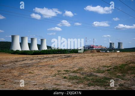 Les grandes tours de refroidissement des centrales nucléaires sont hautes au loin par une journée ensoleillée. Banque D'Images