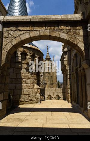 Astorga, Espagne - 4 juin 2023 : une arche de pierre mène à une vue sur le Palais épiscopal d'Astorga, Espagne. Banque D'Images