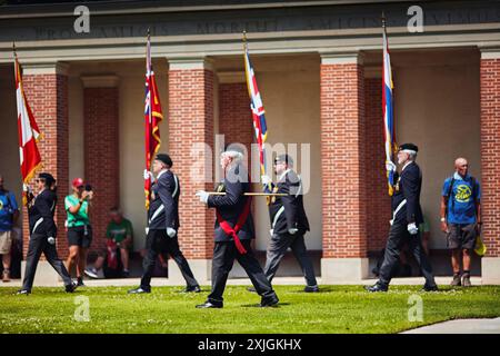 Groesbeek, pays-Bas. 18 juillet 2024. Les participants aux Marches des 4Jays observent la garde d’honneur au cimetière canadien pendant la troisième journée de marche. Le cimetière contient les tombes de 2 619 soldats morts pendant la seconde Guerre mondiale. Les marcheurs se tiennent devant la Croix du sacrifice, une croix faite de pierre de Portland avec une épée en métal sur le dessus. Cette année marque le 80e anniversaire d'un raid aérien de grande envergure à Groesbeek dans le cadre de l'opération Market Garden. Crédit : SOPA images Limited/Alamy Live News Banque D'Images