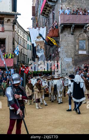 Les bœufs blancs et la bannière de soie du Palio (le Carroccio) arrivent sur la Piazza Del Campo dans le cadre de la procession historique, le Palio, Sienne, Italie. Banque D'Images