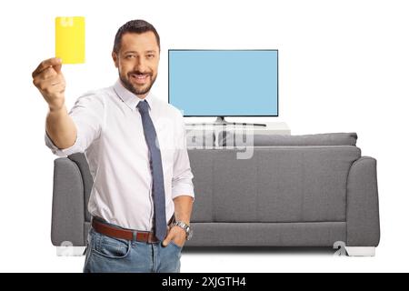 Homme d'affaires montrant un carton jaune devant la télévision et souriant isolé sur fond blanc Banque D'Images