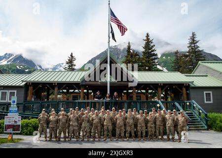 Le 128th Air ravitaillement Wing civil Engineer Squadron pose aux côtés du personnel devant le Seward Military Resort, un site de projet dont ils ont été rénovés au cours de leur déploiement à court terme, Seward, Alaska, 27 juin 2024. Dans le cadre des rénovations, 128 membres du service ARW ont rénové la maison d'emballage et de nettoyage du poisson du complexe, reconstruit une cabane en rondins, construit un toit au-dessus du congélateur du complexe et créé une dalle de béton pour un foyer. (Photo de la Garde nationale aérienne américaine par Airman 1re classe Cynthia Yang) Banque D'Images