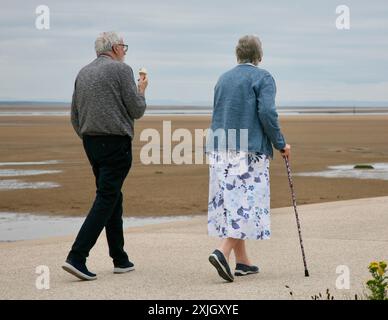 Un couple de personnes âgées dégustant une glace au bord de la mer Banque D'Images