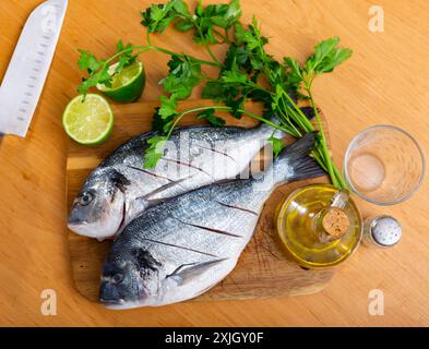 Deux couvre-oreillers reposant sur une planche à découper avec du citron vert et du persil Banque D'Images