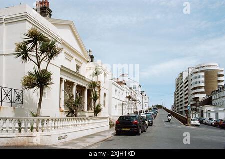 Maisons géorgiennes et victoriennes le long de East Ascent, St Leonards-on-Sea, East Sussex, Royaume-Uni, avec le bâtiment Marine court des années 1930 en arrière-plan Banque D'Images