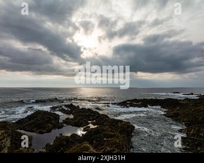 Soleil brille à travers un trou dans les nuages au-dessus de la côte accidentée de Newquay, cornouailles Banque D'Images