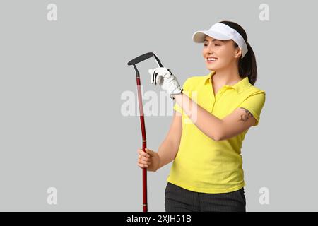 Belle golfeuse féminine sur fond gris Banque D'Images