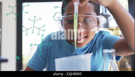 Mener une expérience scientifique, enfant avec des lunettes de sécurité sur des formules chimiques image Banque D'Images