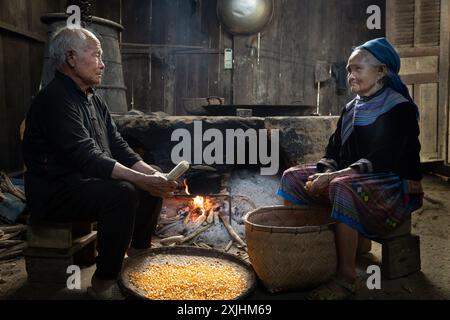 Fleur Hmong homme et femme décortiquant du maïs dans leur cuisine à bac Ha, province de Lao Cai, Vietnam Banque D'Images