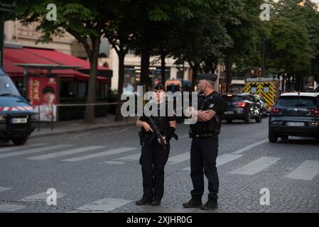 Des policiers et des gendarmes sécurisent la zone devant le magasin Louis Vuitton après qu’un homme ait attaqué un policier avec un couteau, avenue des champs-Élysées à Paris, France, le 18 juillet 2024. Un homme a été grièvement blessé par balle après avoir attaqué un policier avec un couteau dans la ville hôte des Jeux Olympiques à Paris jeudi soir. Des sources policières ont indiqué que l’assaillant, qui a reçu des blessures mettant sa vie en danger, avait été refoulé d’une boutique Louis Vuitton, qui avait demandé à la police d’intervenir. Photo Florian Poitout/ABACAPRESS. COM Banque D'Images