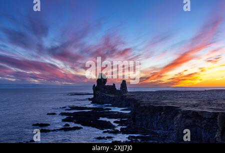 Les piles de mer spectaculaires de Londrangar, péninsule de Snaefellsnes, Islande. Au coucher du soleil, avec un ciel coloré et les rochers en silhouette. Banque D'Images