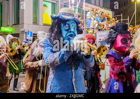 Lucerne, Suisse - 21 février 2023: Groupe de musiciens en costumes marche dans les rues, partie de la dernière parade nocturne du Carnaval de Fasnacht, Banque D'Images