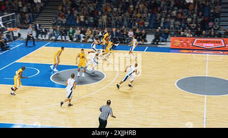 Retransmission télévisée de deux équipes internationales jouant au basket-ball dans une arène professionnelle. Les équipes Dribble, Pass the Ball, Sucessfuly marquent des buts lors d'un match de championnat du monde intense. Banque D'Images