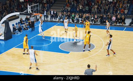 Retransmission télévisée de deux équipes internationales jouant au basket-ball dans une arène professionnelle. Les deux équipes Dribble, Pass the Ball, marquent des buts lors d'un match de championnat du monde intense. Banque D'Images