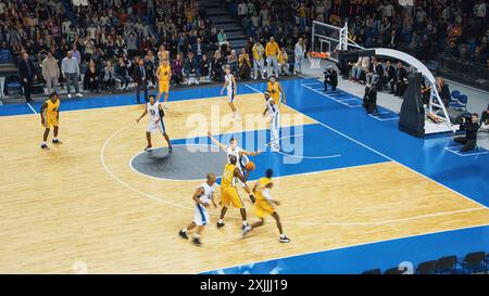Retransmission télévisée de deux équipes internationales jouant au basket-ball dans une arène professionnelle. Les deux équipes Dribble, Pass the Ball, Sucessfuly marquent des buts lors d'un match intense de championnat du monde. Banque D'Images