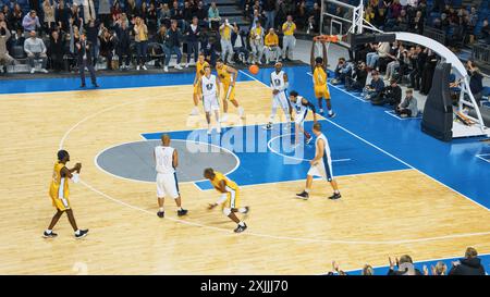 Images de style télévisé du championnat de basket-ball : équipe jaune passant le ballon, joueur obtenant un but avec une Dunk qui rapproche l'équipe multiculturelle de la victoire. Concept Live Sport Channel. Banque D'Images