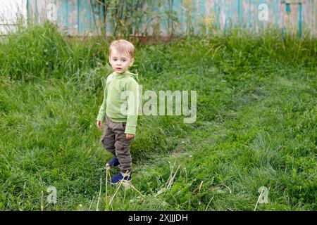 Enfant en bas âge explorant la nature dans l'herbe sur la campagne Banque D'Images