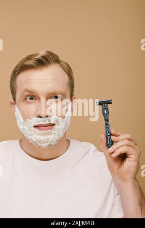 Un homme suave tenant un rasoir prêt pour le toilettage. Banque D'Images