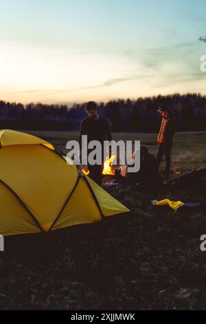 l'homme installe une tente sur un voyage de camping, tente de coucher de soleil de camping. Banque D'Images