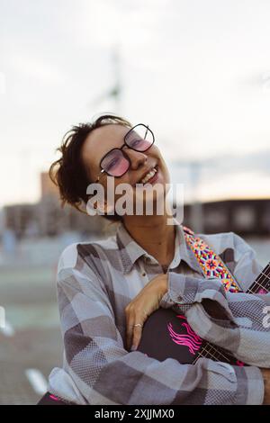 Une jeune femme joue de la guitare sur le toit. Banque D'Images