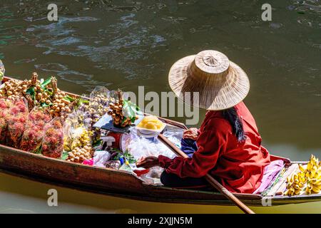 Femme asiatique vendant des fruits au marché flottant Damnoen Saduak, Bangkok Banque D'Images