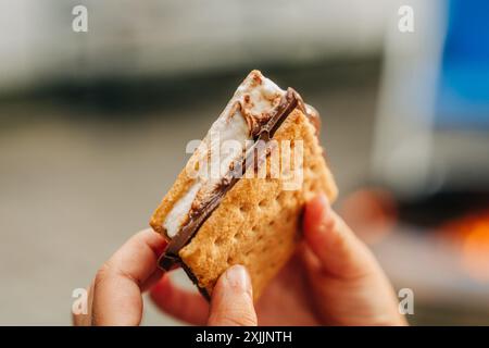 Gros plan des mains tenant un s'More parfaitement fait Banque D'Images