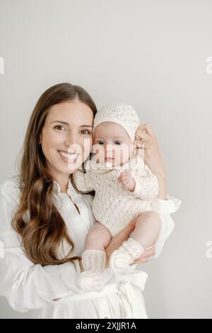 Mère joyeuse tenant fièrement son bébé de 3 mois Banque D'Images