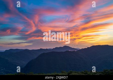 Avant le lever du soleil, les nuages colorés dans le ciel ressemblent à des monstres extraterrestres à venir. Vue sur les montagnes entourant Emerald Reservoir. District de Xindian, Banque D'Images