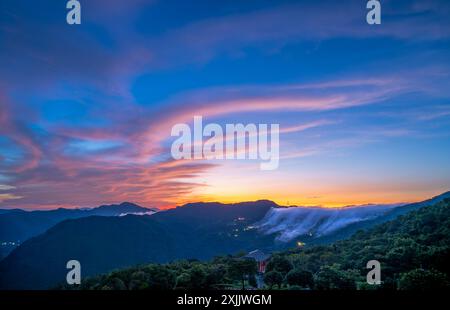 Avant le lever du soleil, les nuages colorés dans le ciel ressemblent à des monstres extraterrestres à venir. Vue sur les montagnes entourant Emerald Reservoir. District de Xindian, Banque D'Images