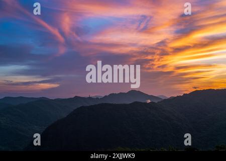 Avant le lever du soleil, les nuages colorés dans le ciel ressemblent à des monstres extraterrestres à venir. Vue sur les montagnes entourant Emerald Reservoir. District de Xindian, Banque D'Images