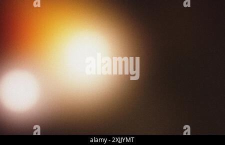 Fond abstrait avec des fuites de lumière chaude sur fond sombre et texture granuleuse Banque D'Images