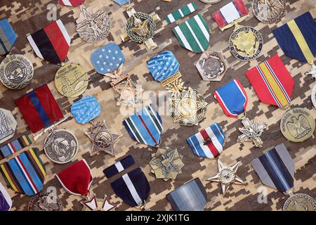 KIEV, UKRAINE - 10 JUILLET 2024 de nombreuses médailles militaires américaines sur fond de camouflage. Les États-Unis décernent des médailles. Accessoires de théâtre en papier faits à la main en gros plan Banque D'Images