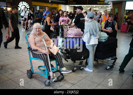 Elaine Bevan, 70 ans, de Southampton, attend dans le terminal sud de l'aéroport de Gatwick à Crawley, dans l'est du Sussex, car les pannes INFORMATIQUES généralisées affectant les compagnies aériennes, les radiodiffuseurs et les banques ont causé de longues files d'attente. Date de la photo : vendredi 19 juillet 2024. Banque D'Images