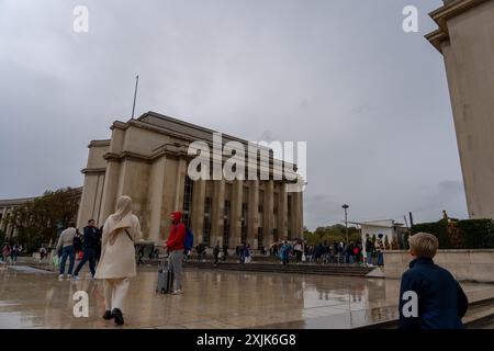 Paris, France - 18 octobre 2023 : Un grand bâtiment imposant à Paris, France, avec une place humide en pierre devant et des gens qui marchent. Banque D'Images