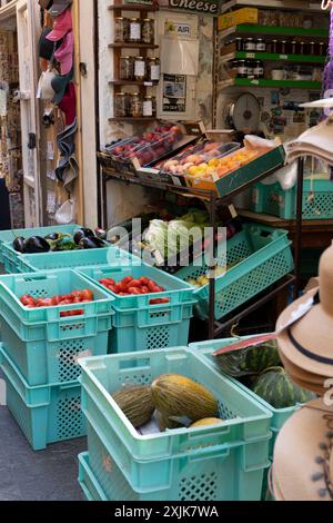 Un étal de marché local dynamique présentant des fruits et légumes frais dans des caisses en plastique bleu. Parfait pour les concepts liés à la nourriture fraîche et extérieur mar Banque D'Images