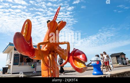 Brighton UK 19 juillet 2024 - les foules et les coquillages en plastique géants profitent du soleil chaud sur le front de mer de Brighton avec des températures prévues pour atteindre 30 degrés dans certaines parties du Sud-est : crédit Simon Dack / Alamy Live News Banque D'Images