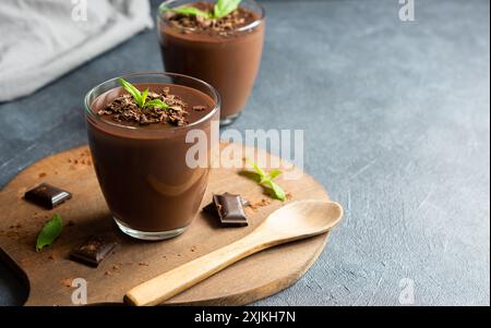 Pudding au chocolat et au cacao, mousse dans une tasse en verre sur une table rustique, supangle Banque D'Images