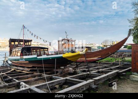 Porto, Portugal - 26 novembre 2023 : ancien chantier naval le long du fleuve Douro avec deux bateaux d'excursion à Porto ou Porto, Portugal Banque D'Images