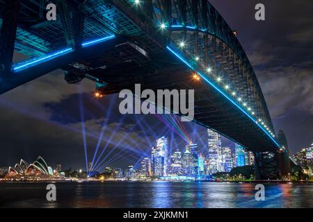 Une vue sur les gratte-ciel de Sydney, en Australie, et le Harbour Bridge, tous deux illuminés de couleurs lors du festival « Vivid Sydney ». Banque D'Images