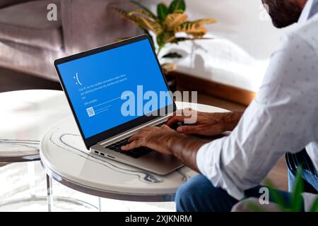 Homme avec ordinateur portable montrant l'écran bleu de la mort ou BSOD sur l'écran du moniteur. Système d'exploitation Microsoft Windows 10 défectueux. Rosario, Argentine - 19 juillet Banque D'Images